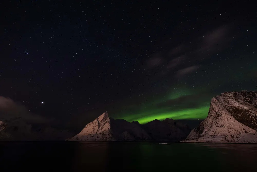 Northern lights over snow-covered mountains