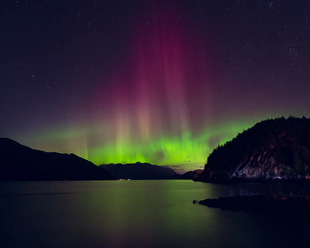 Northern lights reflecting over a calm lake